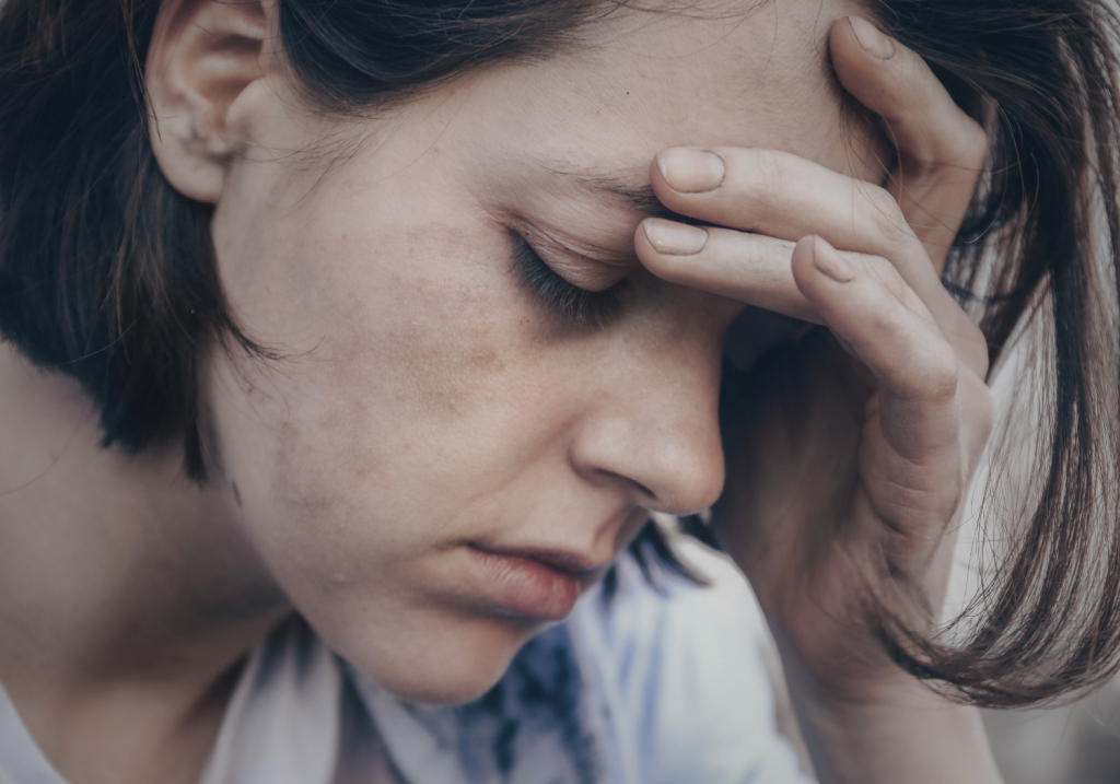 girl with her hand to her head looking frustrated