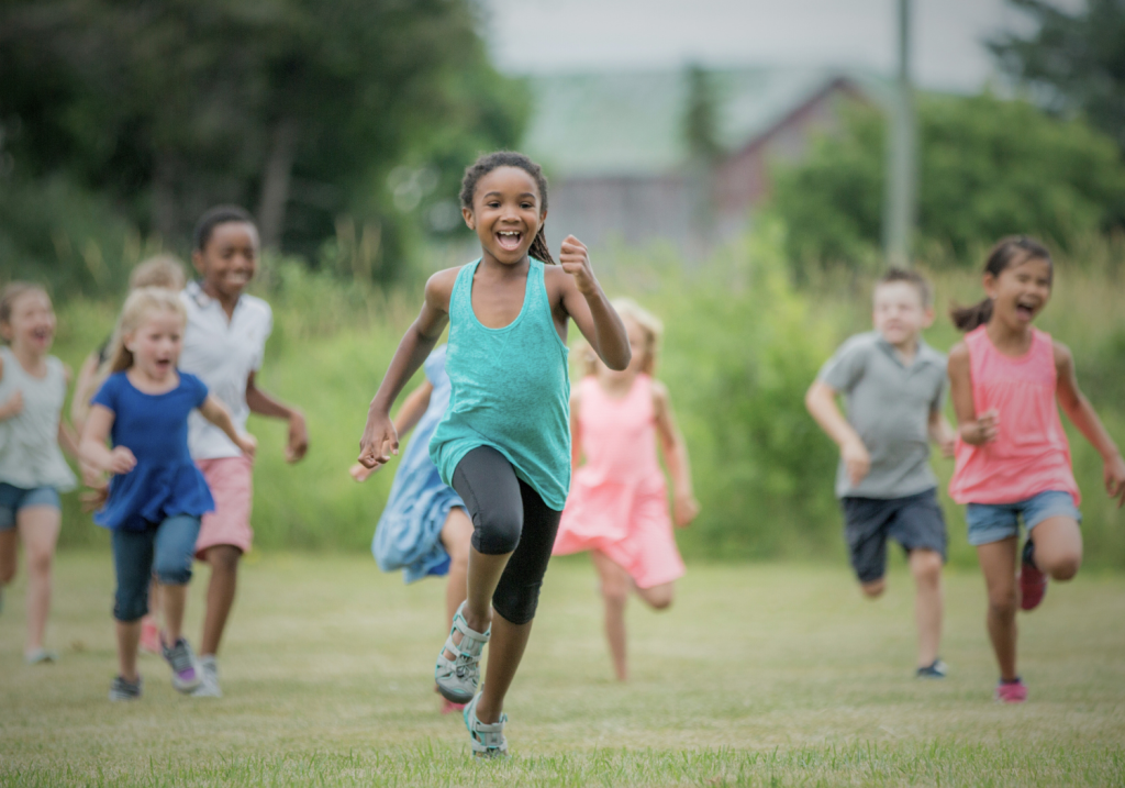 group of kids running in a field